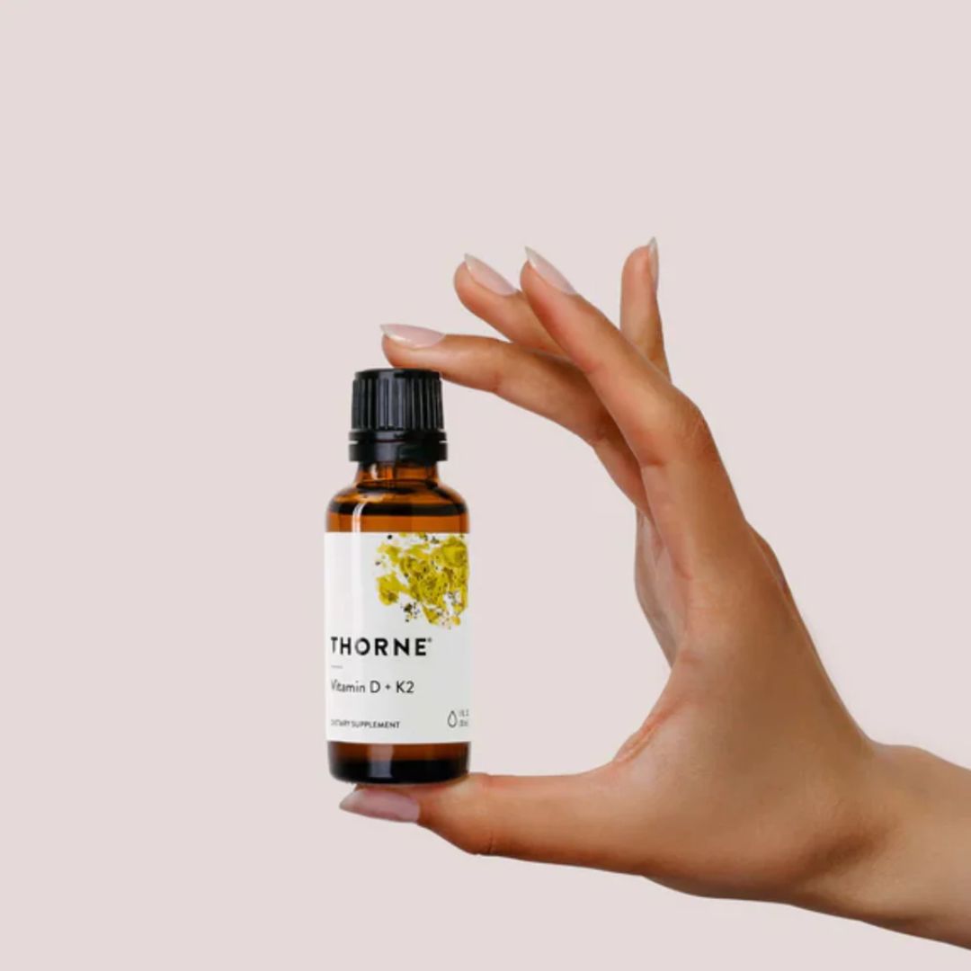 Thorne Vitamin D and K2 liquid drops bottle with dropper MCT oil base vitamin supplement label close up studio product image